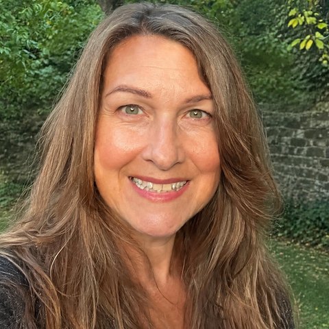 Sue Samsonov, co-founder of BellaPause, smiling in a garden.